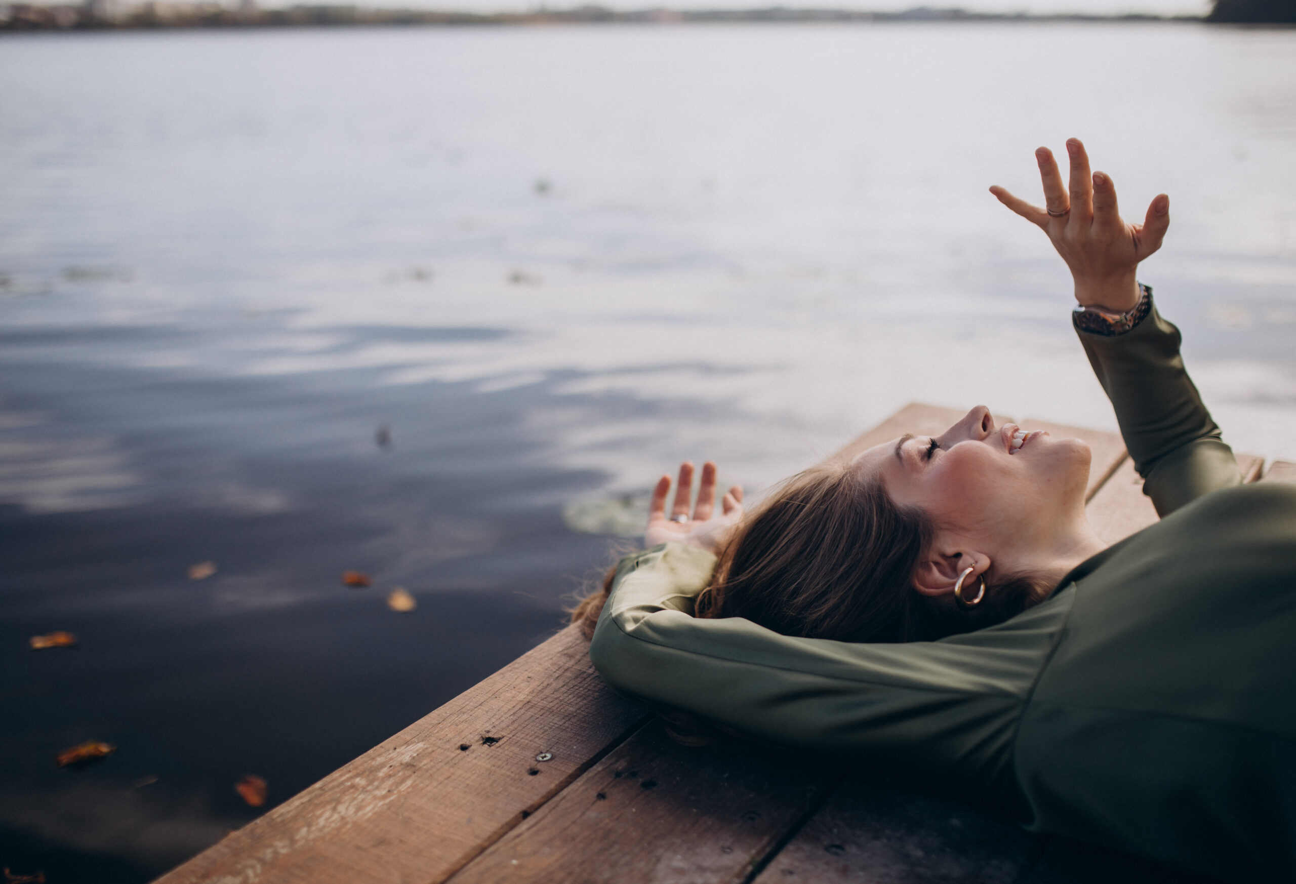 Young beautiful woman lying by the lake